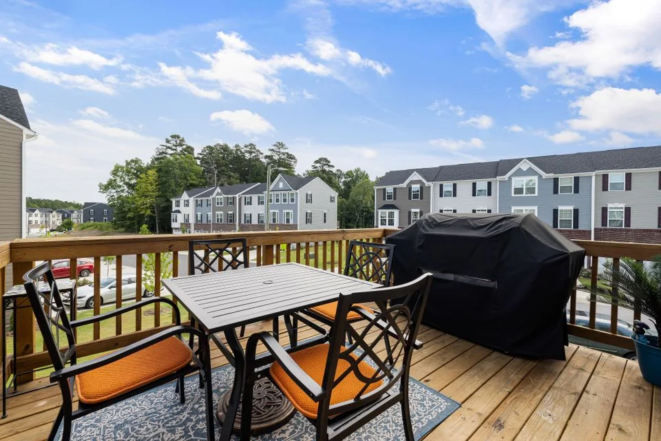Finished wooden deck with outdoor table and chairs.