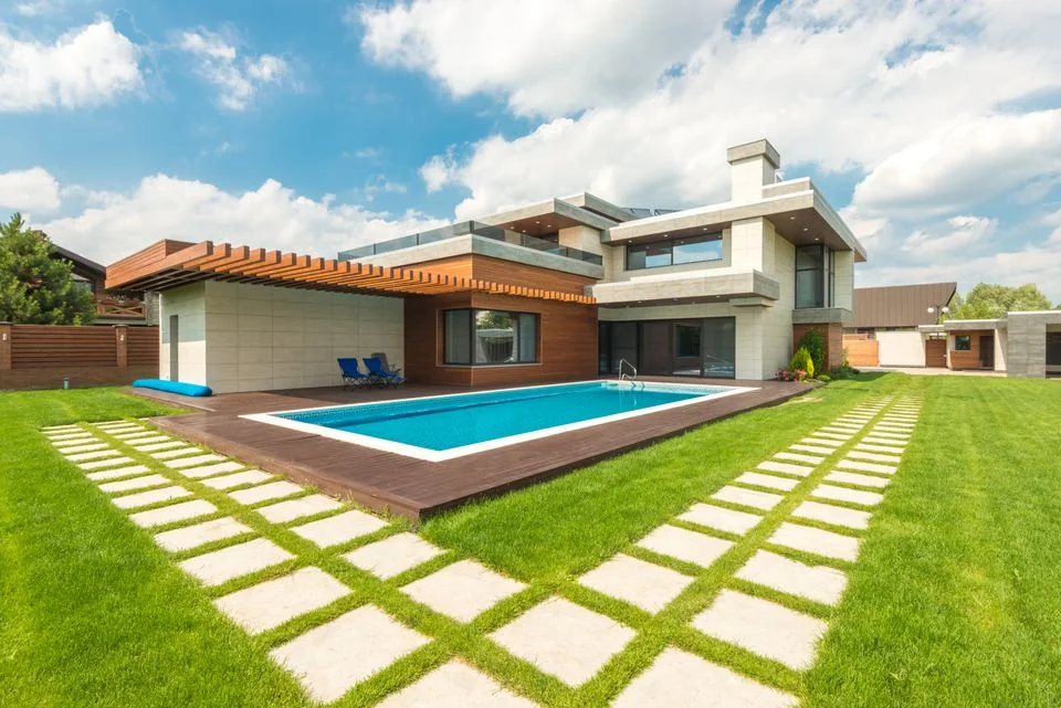 Completed backyard swimming pool beside a contemporary home.